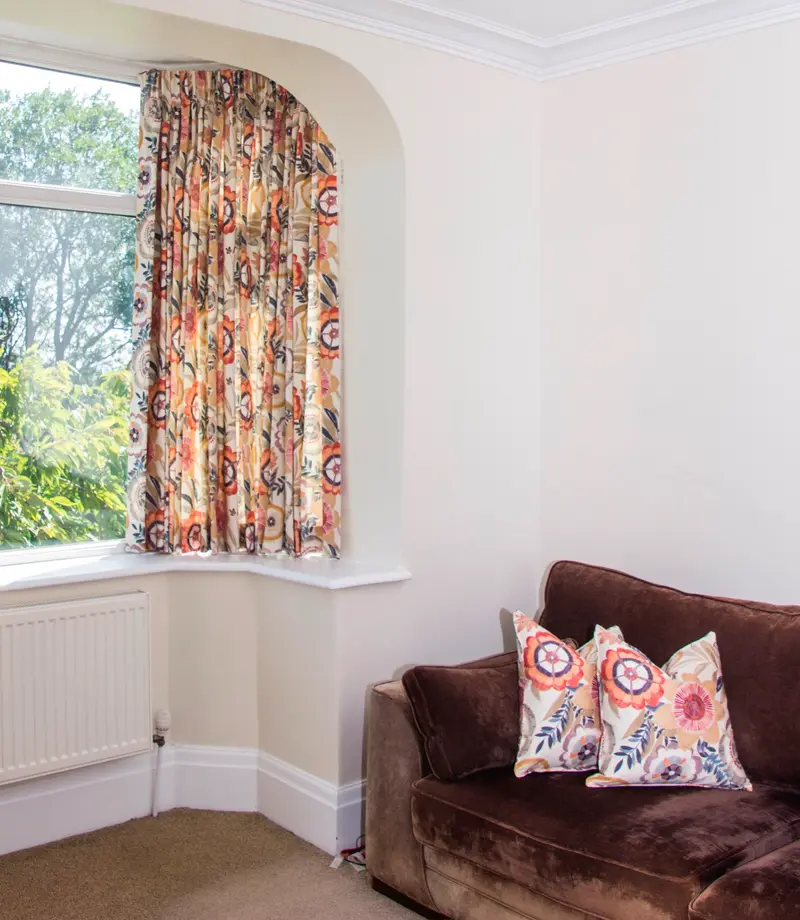 Floral curtains in a bay window by Heather Horrocks Leigh