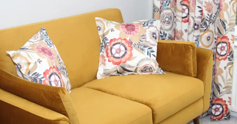 Floral cushions on a mustard sofa by Heather Horrocks Leigh