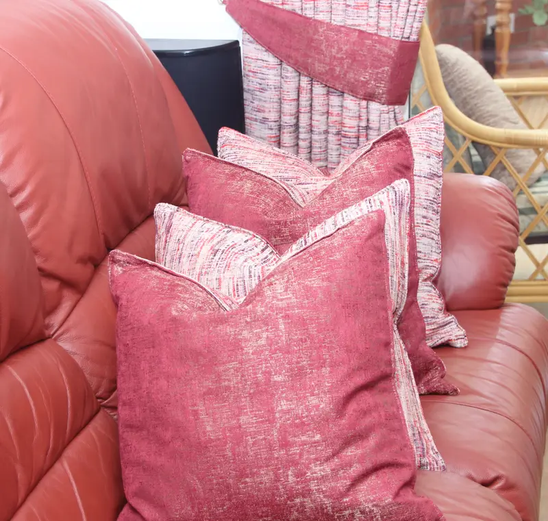 Pink velvet cushions on a leather sofa by Heather Horrocks Leigh