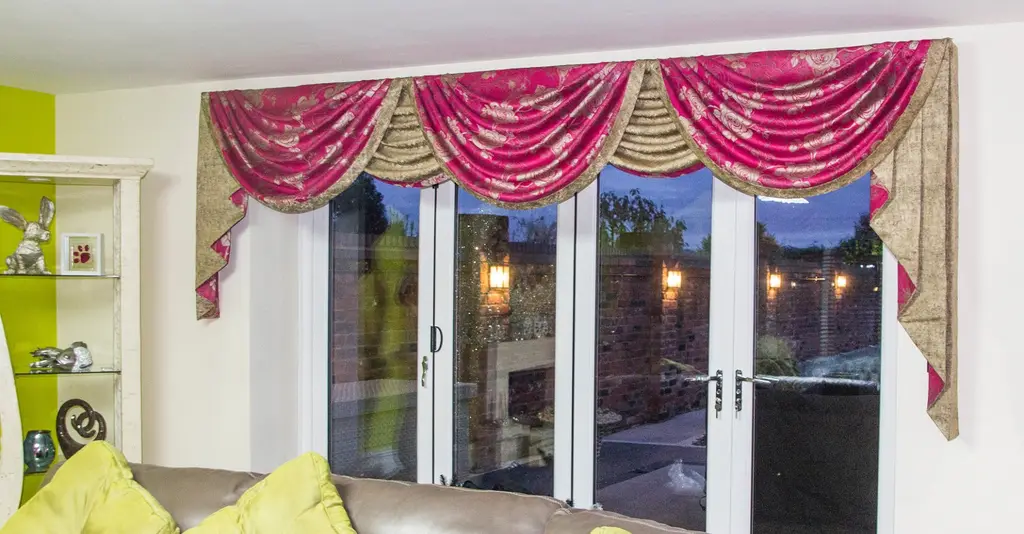 Raspberry and gold swags and tails over patio doors by Heather Horrocks Leigh