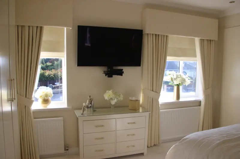 Cream curtains and pelmets in a bedroom by Heather Horrocks Leigh