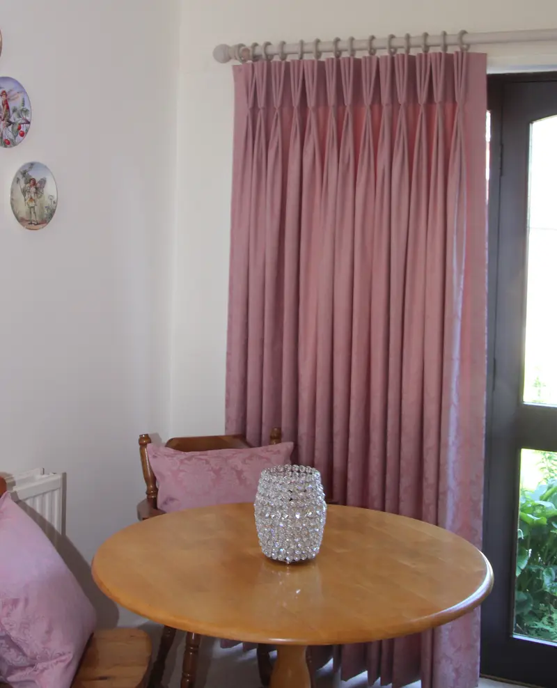 Pink pinch pleat curtains in a dining area by Heather Horrocks Leigh
