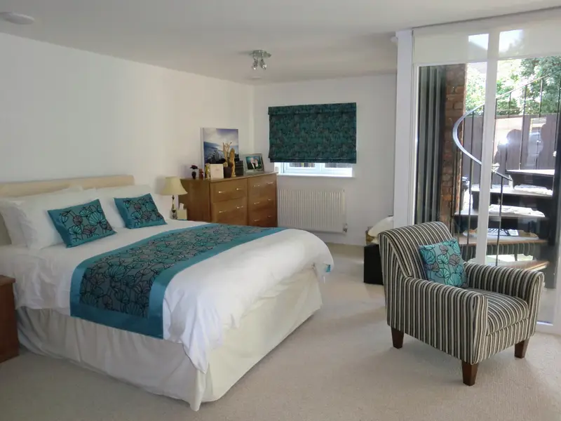 Teal bed runner and Roman blind in a bedroom by Heather Horrocks Leigh